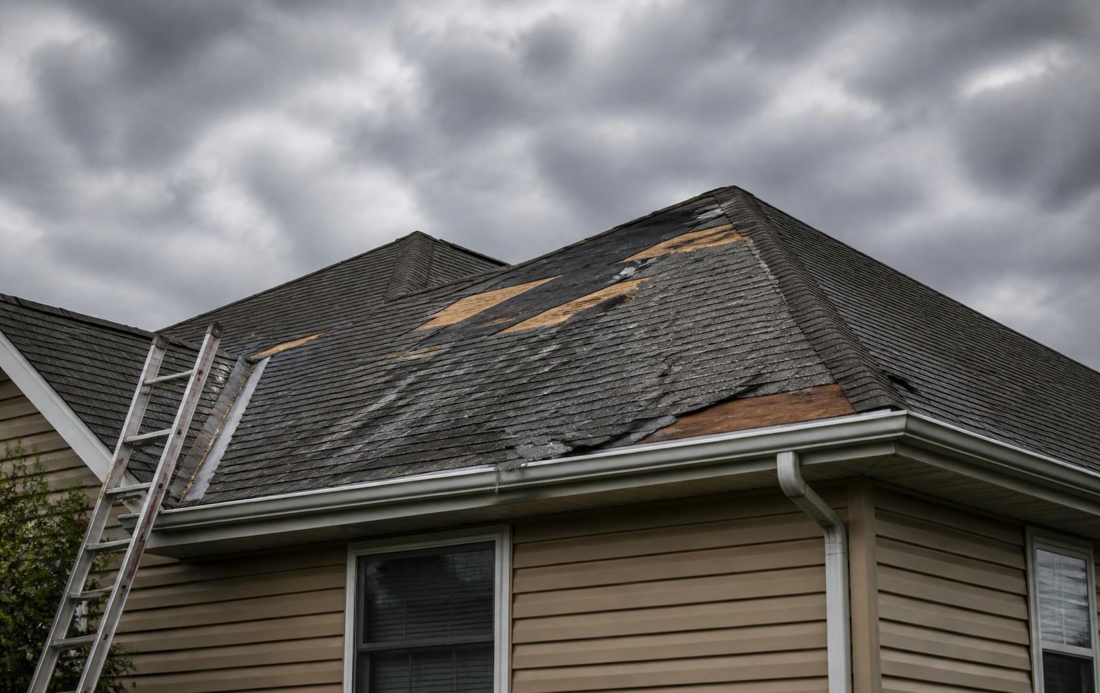 Storm-damaged residential roof with missing shingles